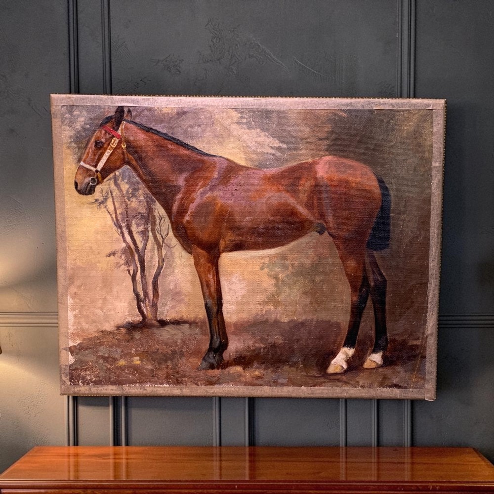 An early 20th-century oil painting on canvas depicting a profile view of a brown thoroughbred horse standing in a landscape.