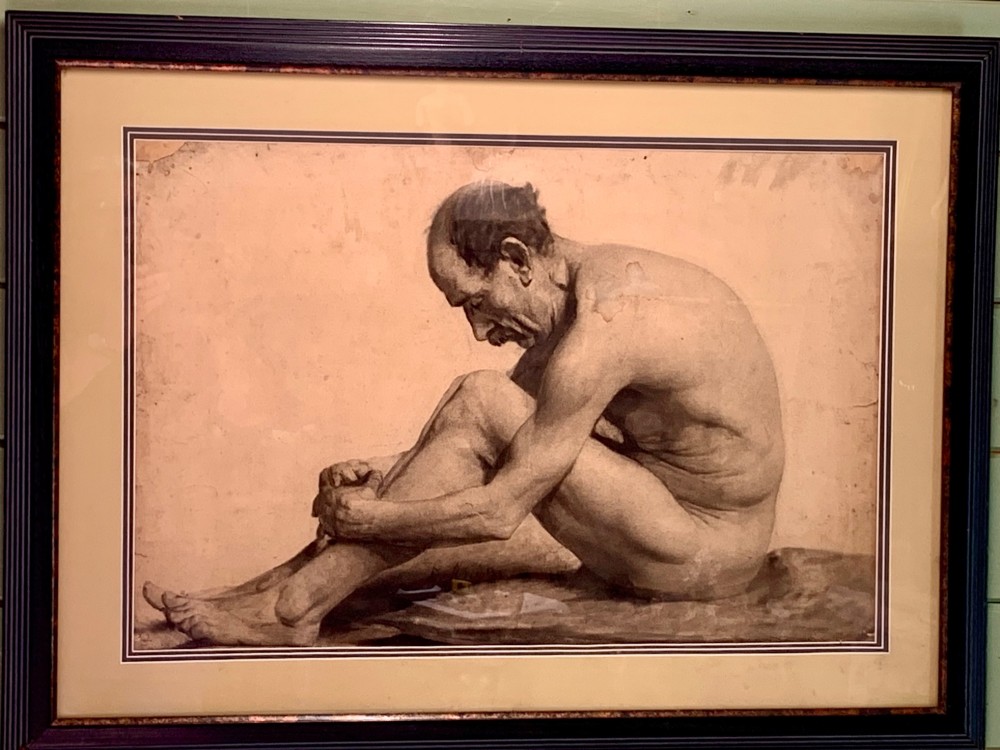 A monochrome academic paper drawing depicting a seated, bowed male nude in profile with detailed anatomical shading. View V