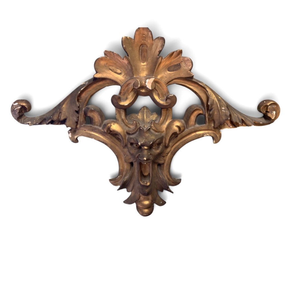 A set of three carved gold giltwood wall fragments decorated with central mascaron faces and scrolling acanthus leaves. View V
