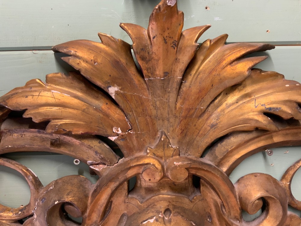 A set of three carved gold giltwood wall fragments decorated with central mascaron faces and scrolling acanthus leaves. View IX