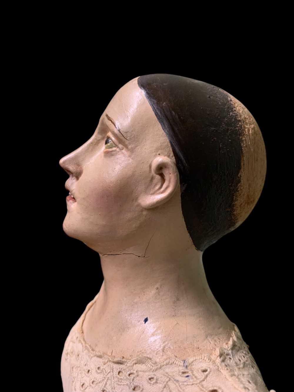 A 19th-century processional mannequin with carved polychrome head and hands, dressed in cream fabric with dark blue sleeves, standing on a four-legged wooden cage base. View IX