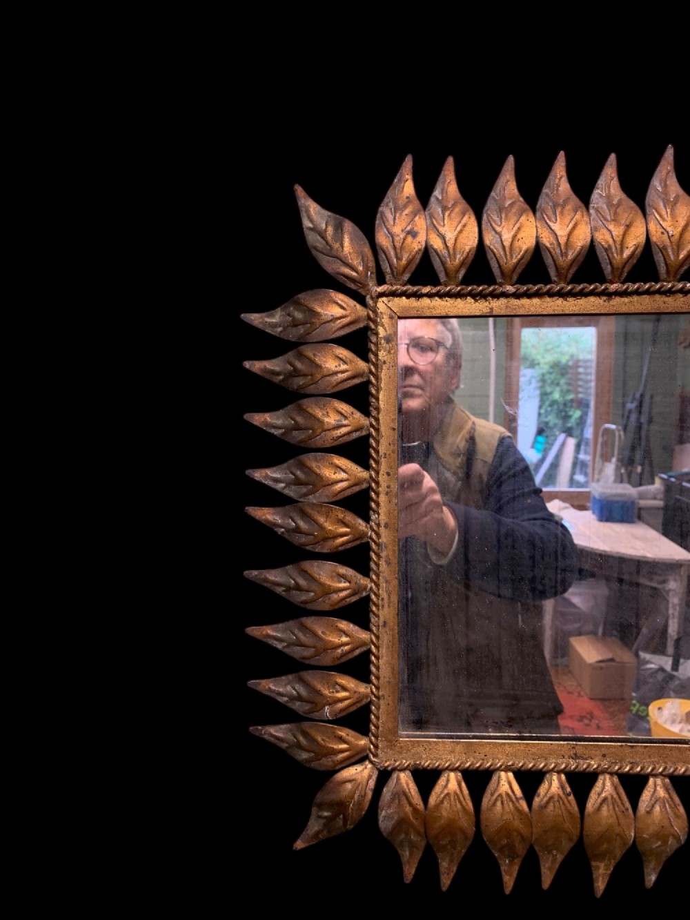 A rectangular horizontal landscape mirror framed in aged gilt metal surrounded by radiating leaf-shaped motifs and a inner rope-twist border. View V
