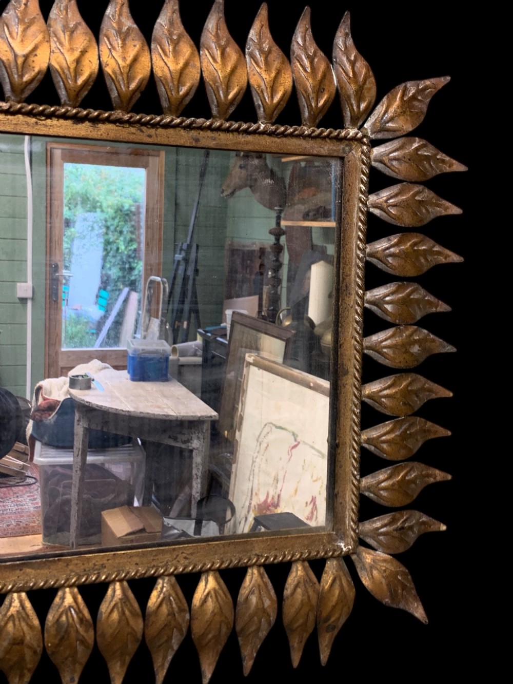 A rectangular horizontal landscape mirror framed in aged gilt metal surrounded by radiating leaf-shaped motifs and a inner rope-twist border. View VI