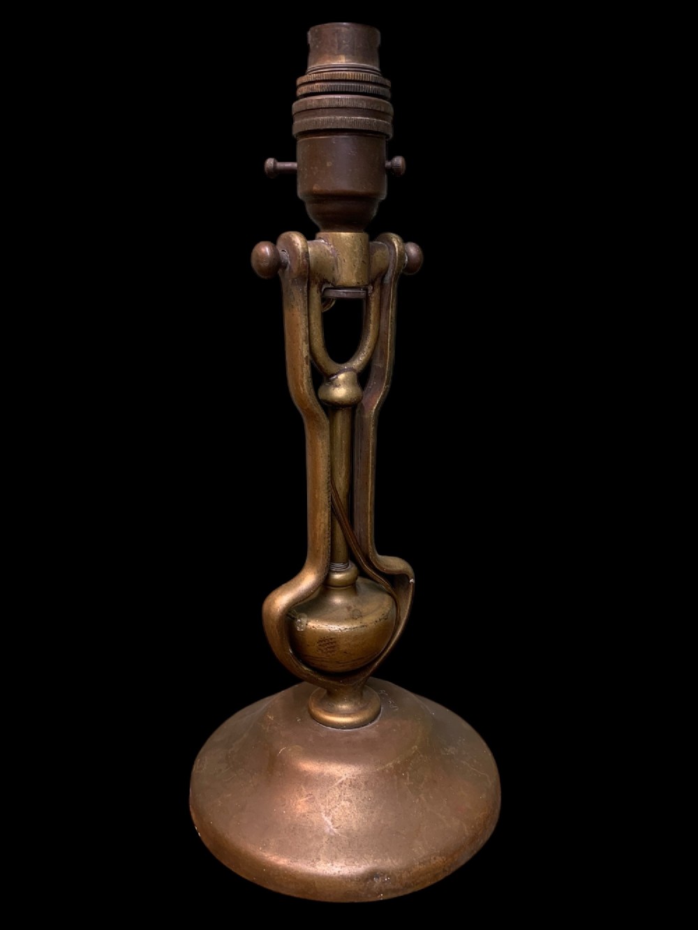 An early twentieth-century patinated brass gimballed ship table lamp featuring a weighted circular base and articulated swivel mechanism. View II