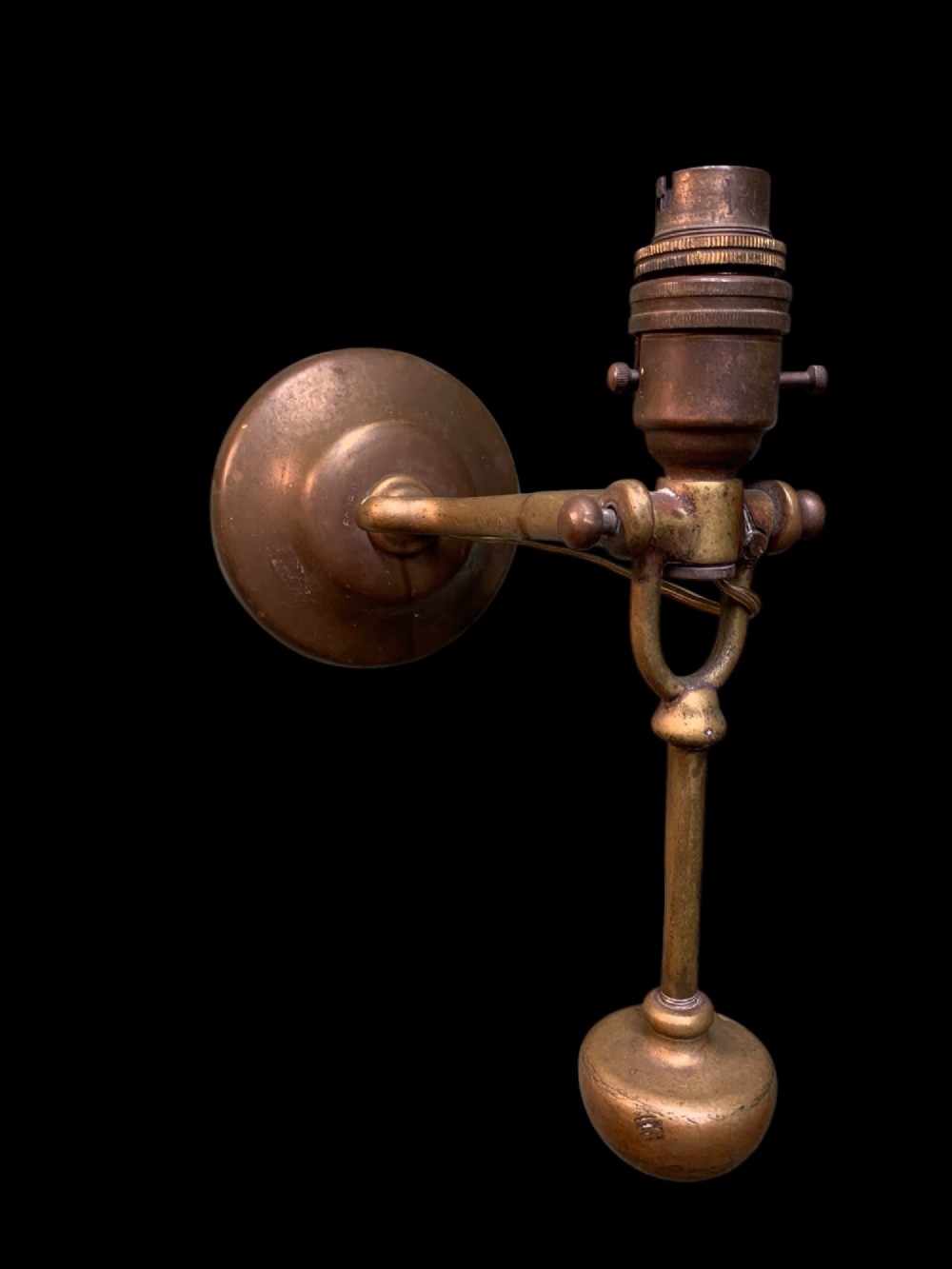 An early twentieth-century patinated brass gimballed ship table lamp featuring a weighted circular base and articulated swivel mechanism. View IV