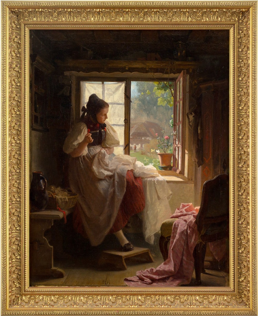 An antique oil painting in a carved gilt frame depicting a young woman in regional attire seated by an open window sewing fabric.