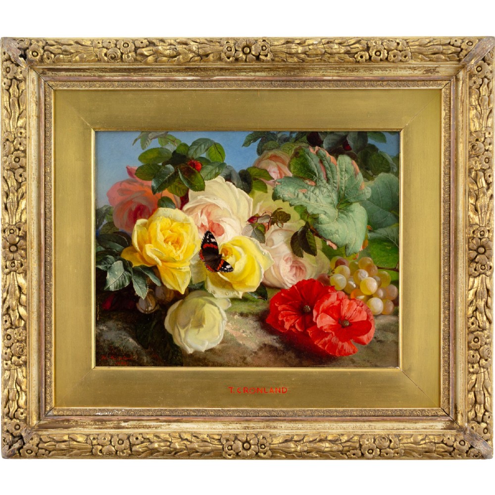 An antique floral still life oil painting displaying red poppies, yellow roses, grapes, and a butterfly, set inside an ornate carved gilt frame.