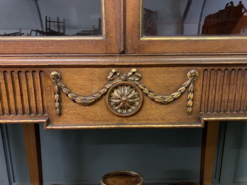 fig 3. An antique mahogany display cabinet featuring glazed centre doors, side inlaid panels, fluted legs, and an arched top.