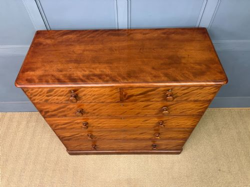 fig 4. A Victorian chest of drawers in warm brown figured timber featuring turned handles and a plinth base.