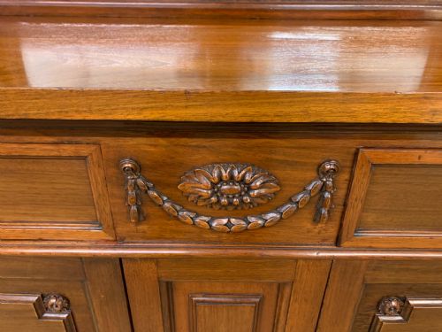 fig 4. An antique walnut hall cupboard featuring a central mirror back, carved swags, drawer storage, lower cupboard doors, and flanking umbrella stands with brass rails.