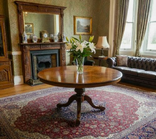 fig 1. A circular burr walnut centre table featuring a quartered figured veneer top over a turned central pedestal with four carved scroll legs.