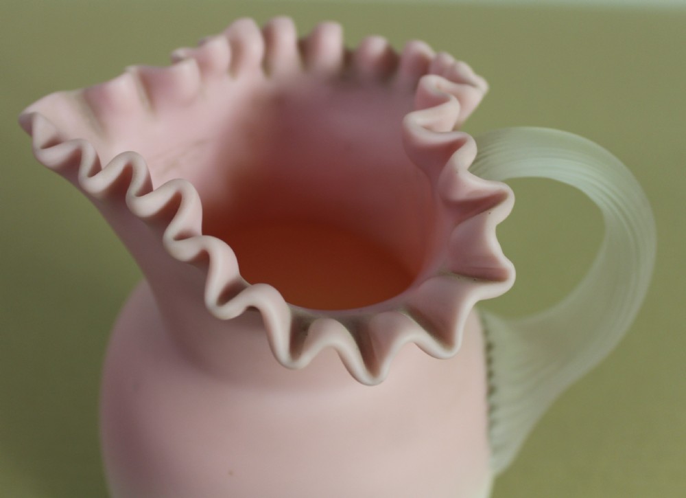 A Victorian Burmese satin glass jug with a shaded pink-to-cream body, a frilled rim, and an applied frosted handle. View VIII