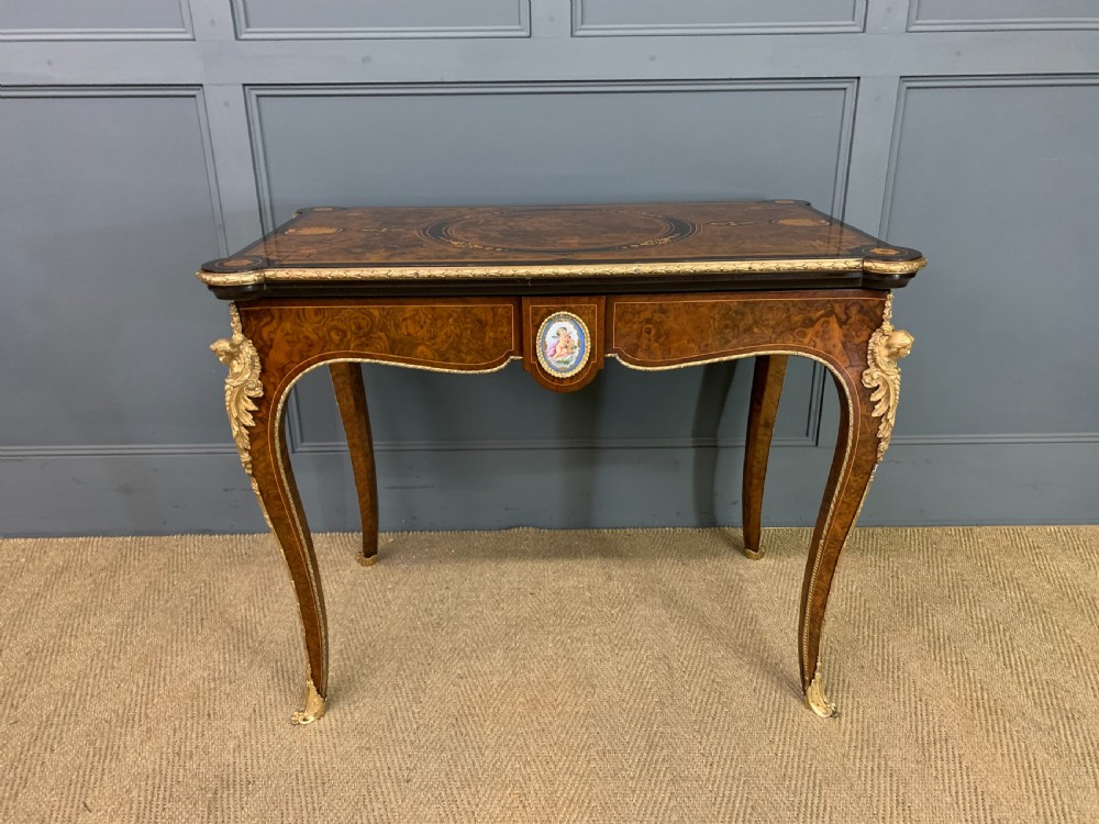 A 19th-century French burr walnut card table featuring intricate marquetry on the top, cabriole legs with gilt-bronze mounts, and a central porcelain plaque on the frieze. View III