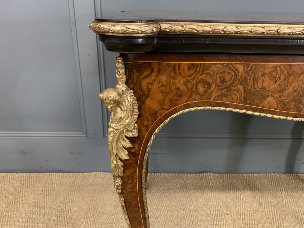 A 19th-century French burr walnut card table featuring intricate marquetry on the top, cabriole legs with gilt-bronze mounts, and a central porcelain plaque on the frieze. View VII