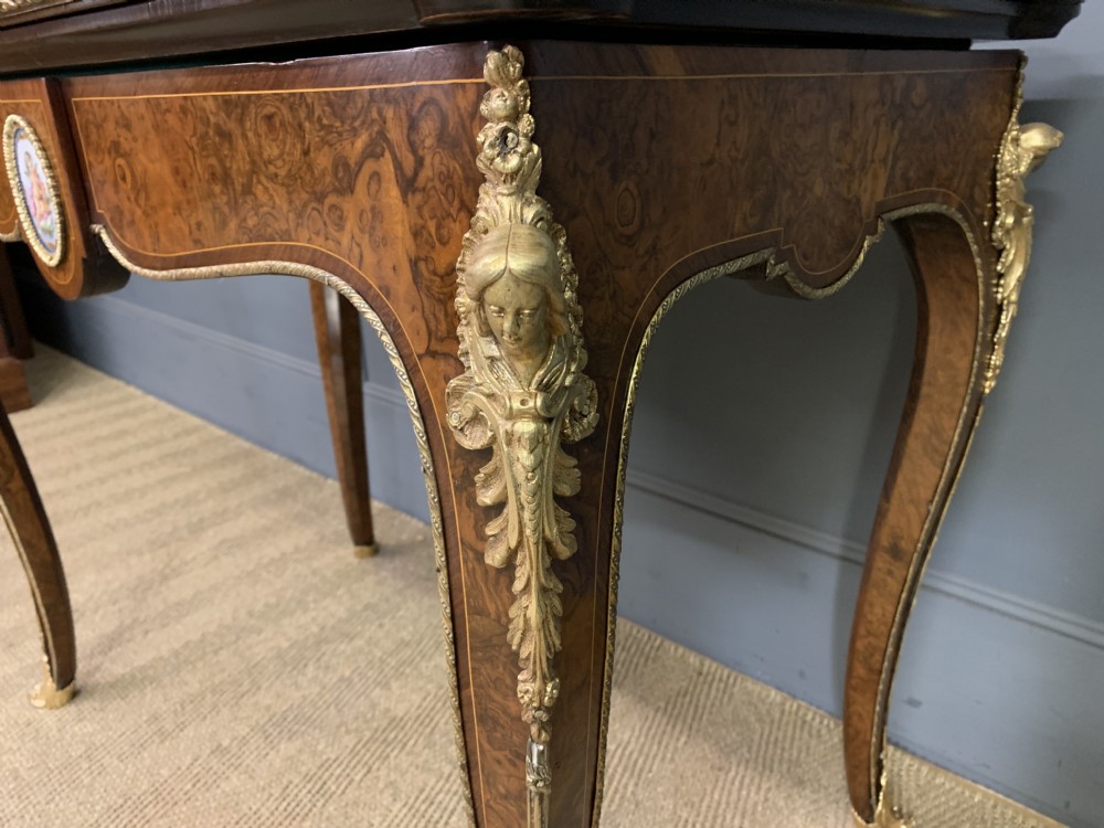 A 19th-century French burr walnut card table featuring intricate marquetry on the top, cabriole legs with gilt-bronze mounts, and a central porcelain plaque on the frieze. View VIII