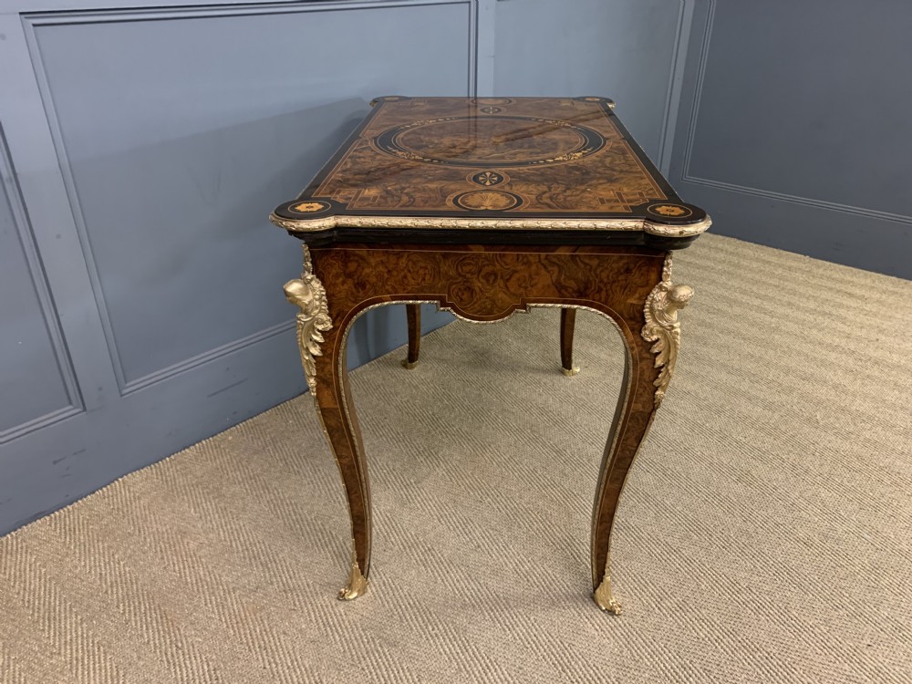 A 19th-century French burr walnut card table featuring intricate marquetry on the top, cabriole legs with gilt-bronze mounts, and a central porcelain plaque on the frieze. View XII