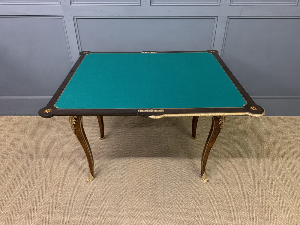A 19th-century French burr walnut card table featuring intricate marquetry on the top, cabriole legs with gilt-bronze mounts, and a central porcelain plaque on the frieze. View XXI