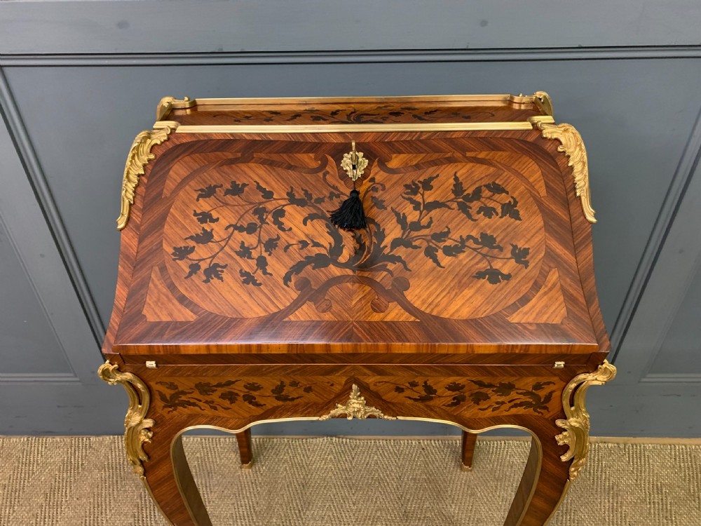 A French Louis XV style kingwood bureau de dame featuring floral marquetry inlays, gilt bronze ormolu mounts, slender cabriole legs, and a slant-front writing slope. View IV