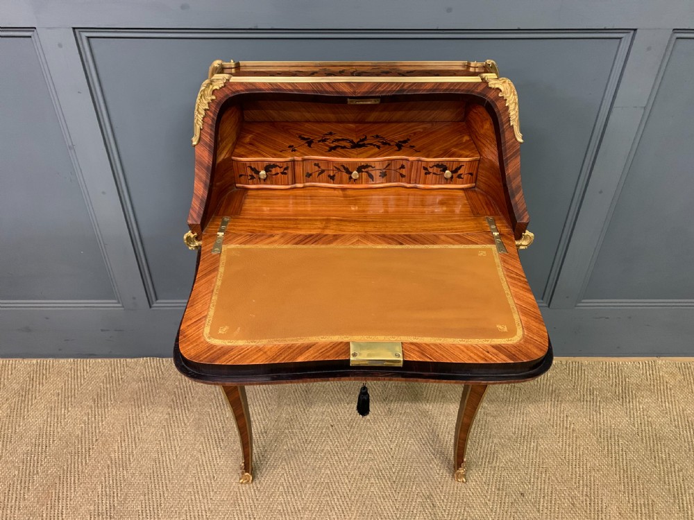 A French Louis XV style kingwood bureau de dame featuring floral marquetry inlays, gilt bronze ormolu mounts, slender cabriole legs, and a slant-front writing slope. View IX
