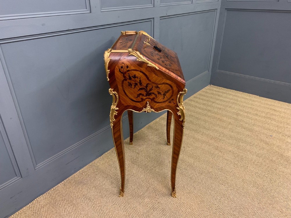 A French Louis XV style kingwood bureau de dame featuring floral marquetry inlays, gilt bronze ormolu mounts, slender cabriole legs, and a slant-front writing slope. View XIII
