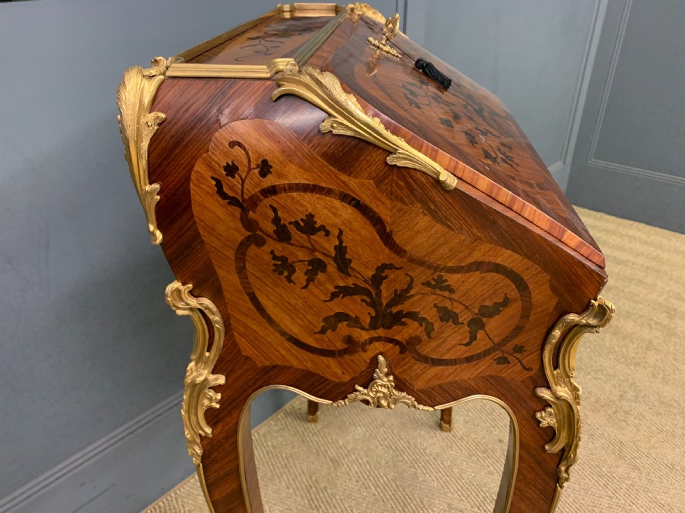 A French Louis XV style kingwood bureau de dame featuring floral marquetry inlays, gilt bronze ormolu mounts, slender cabriole legs, and a slant-front writing slope. View XIV