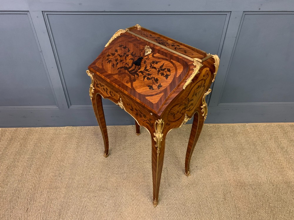 A French Louis XV style kingwood bureau de dame featuring floral marquetry inlays, gilt bronze ormolu mounts, slender cabriole legs, and a slant-front writing slope. View XVII