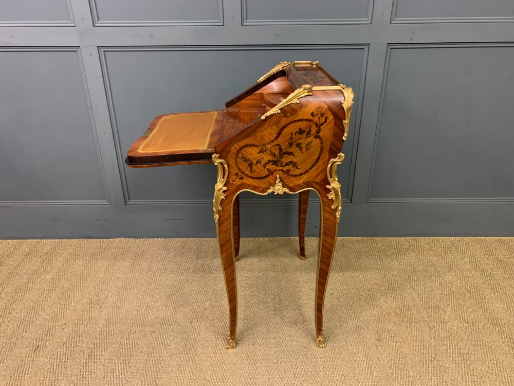 A French Louis XV style kingwood bureau de dame featuring floral marquetry inlays, gilt bronze ormolu mounts, slender cabriole legs, and a slant-front writing slope. View XVIII