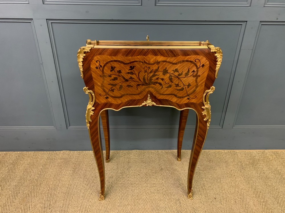 A French Louis XV style kingwood bureau de dame featuring floral marquetry inlays, gilt bronze ormolu mounts, slender cabriole legs, and a slant-front writing slope. View XIX