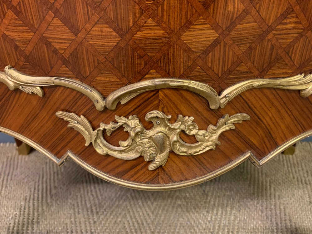 A 19th-century French kingwood vitrine cabinet with glass side panels, geometric parquetry lower door inlay, and ornate gilt-bronze ormolu mounts. View V