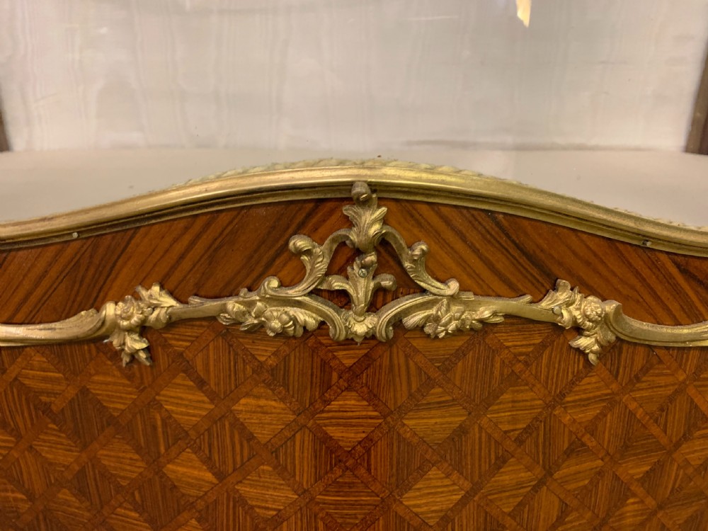 A 19th-century French kingwood vitrine cabinet with glass side panels, geometric parquetry lower door inlay, and ornate gilt-bronze ormolu mounts. View VI