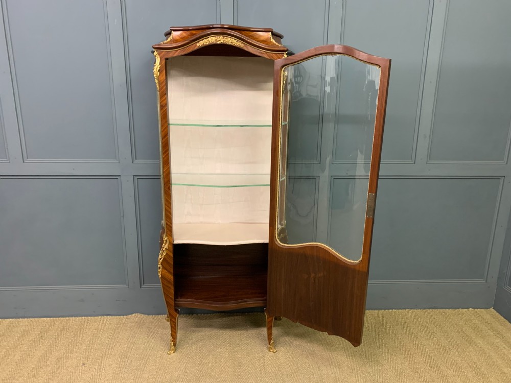 A 19th-century French kingwood vitrine cabinet with glass side panels, geometric parquetry lower door inlay, and ornate gilt-bronze ormolu mounts. View XV