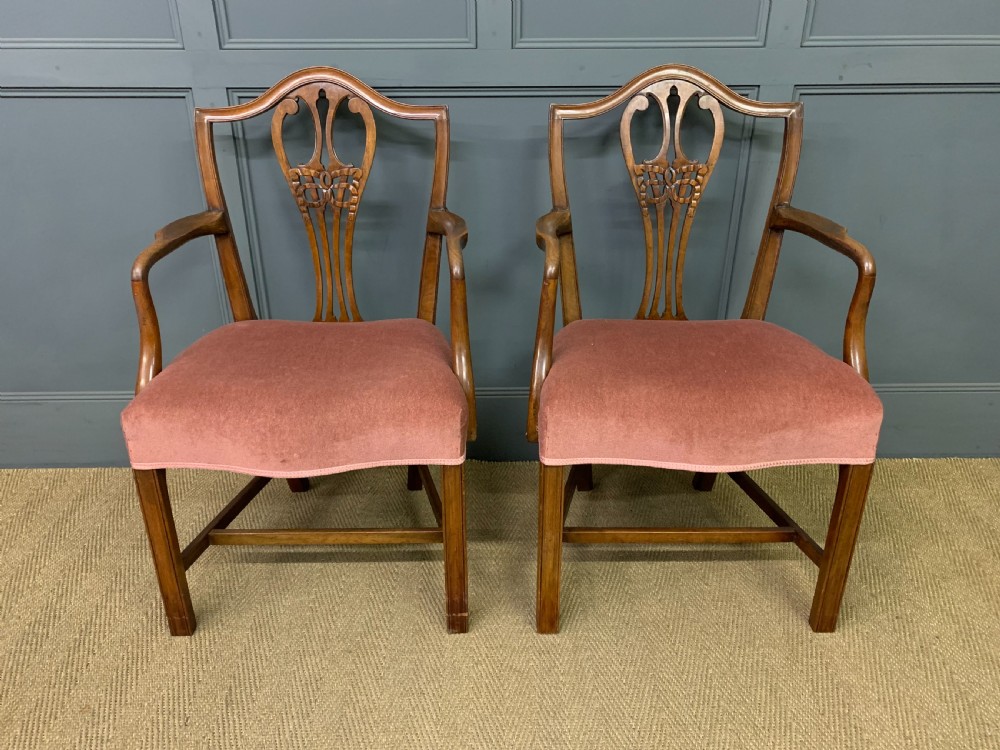 A pair of Georgian mahogany open armchairs with carved pierced splat backs and rose-coloured upholstered seats. View II