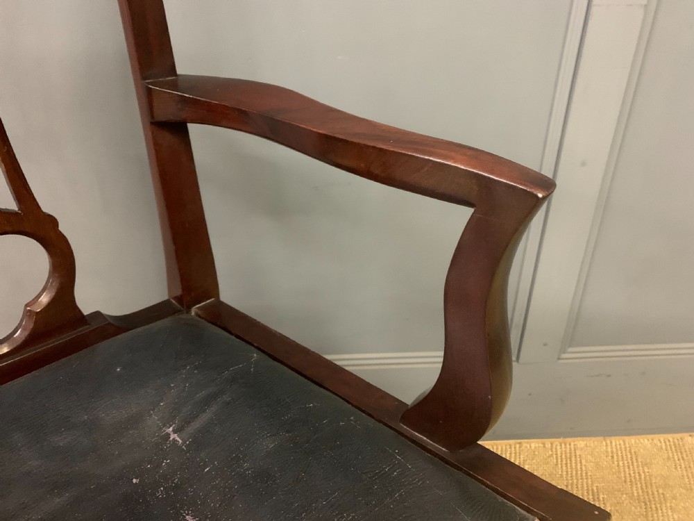 A 19th-century dark mahogany open armchair featuring a carved pierced back splat, swept armrests, and a blue drop-in upholstered seat. View VI