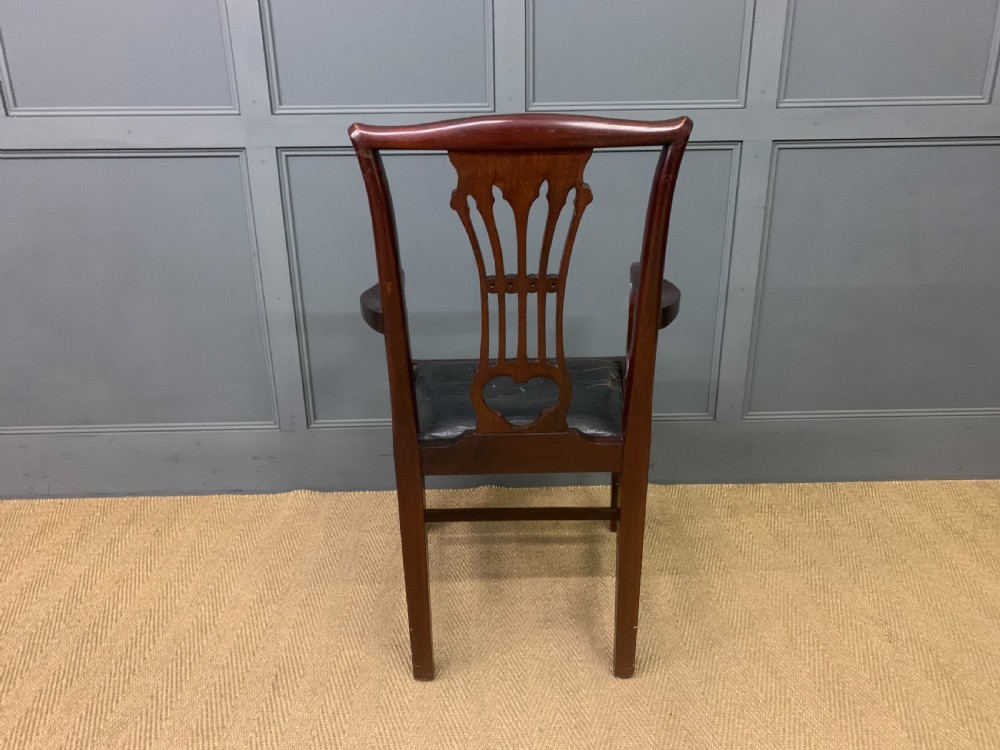 A 19th-century dark mahogany open armchair featuring a carved pierced back splat, swept armrests, and a blue drop-in upholstered seat. View VIII