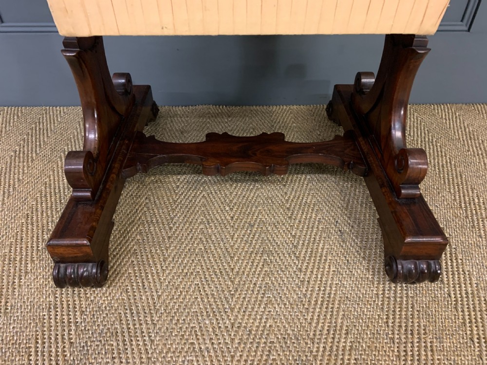 A William IV rosewood work table featuring a figured square top, pleated cream fabric basket, and carved scroll supports. View IV