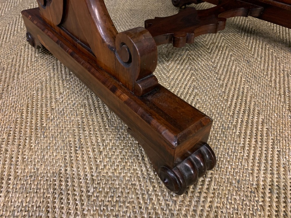 A William IV rosewood work table featuring a figured square top, pleated cream fabric basket, and carved scroll supports. View X