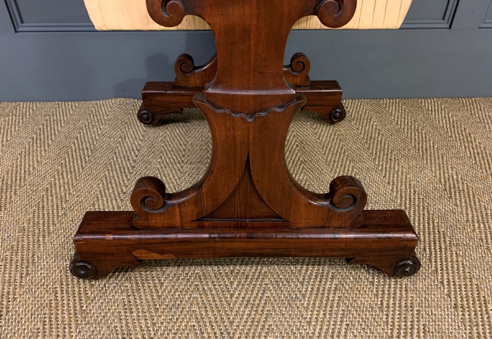 A William IV rosewood work table featuring a figured square top, pleated cream fabric basket, and carved scroll supports. View XII