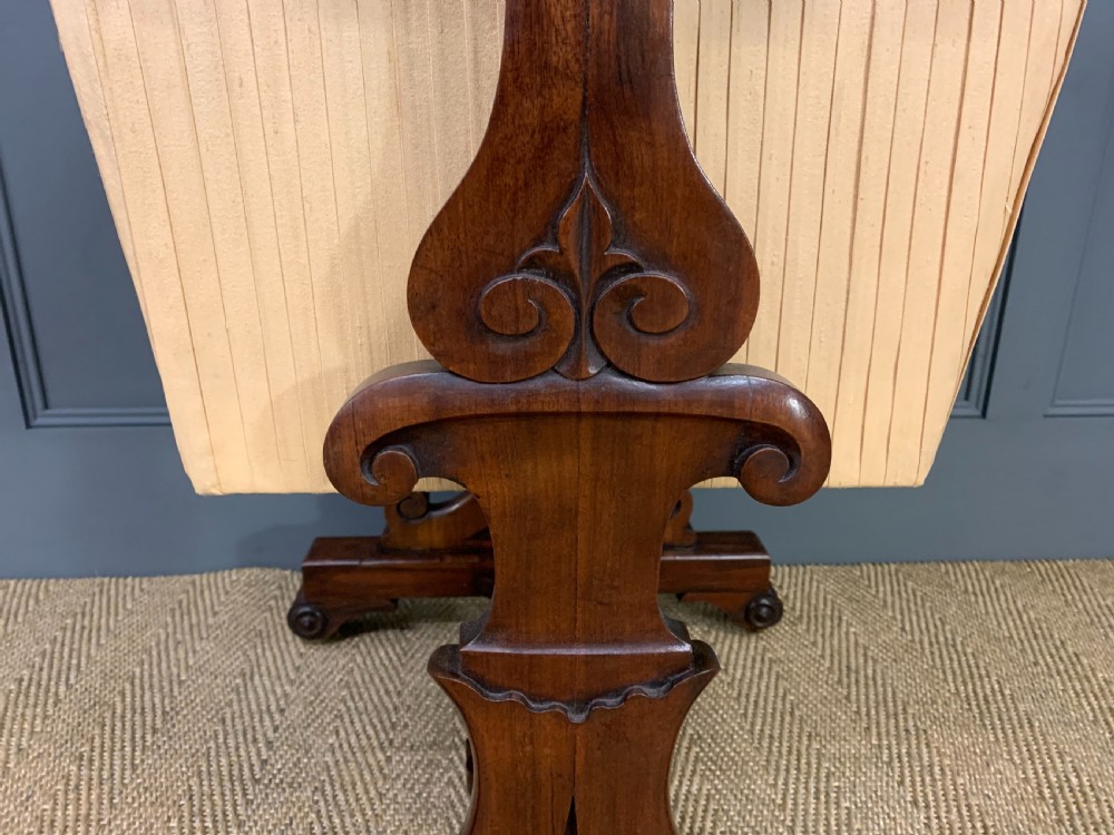 A William IV rosewood work table featuring a figured square top, pleated cream fabric basket, and carved scroll supports. View XIII