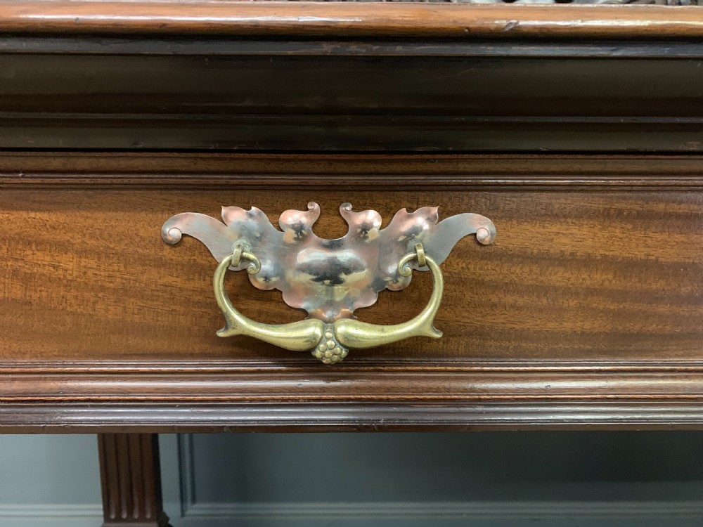 A Victorian mahogany buffet featuring a carved scroll backboard, two frieze drawers with brass handles, fluted support columns, and an open lower tier. View VI