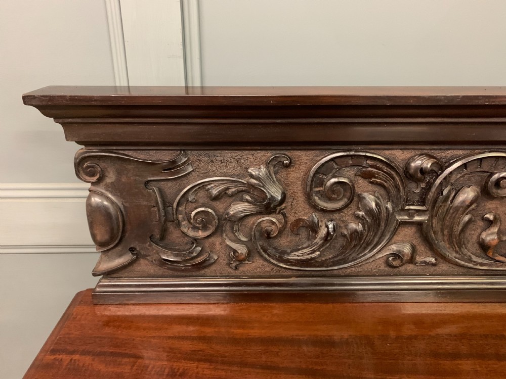 A Victorian mahogany buffet featuring a carved scroll backboard, two frieze drawers with brass handles, fluted support columns, and an open lower tier. View VIII
