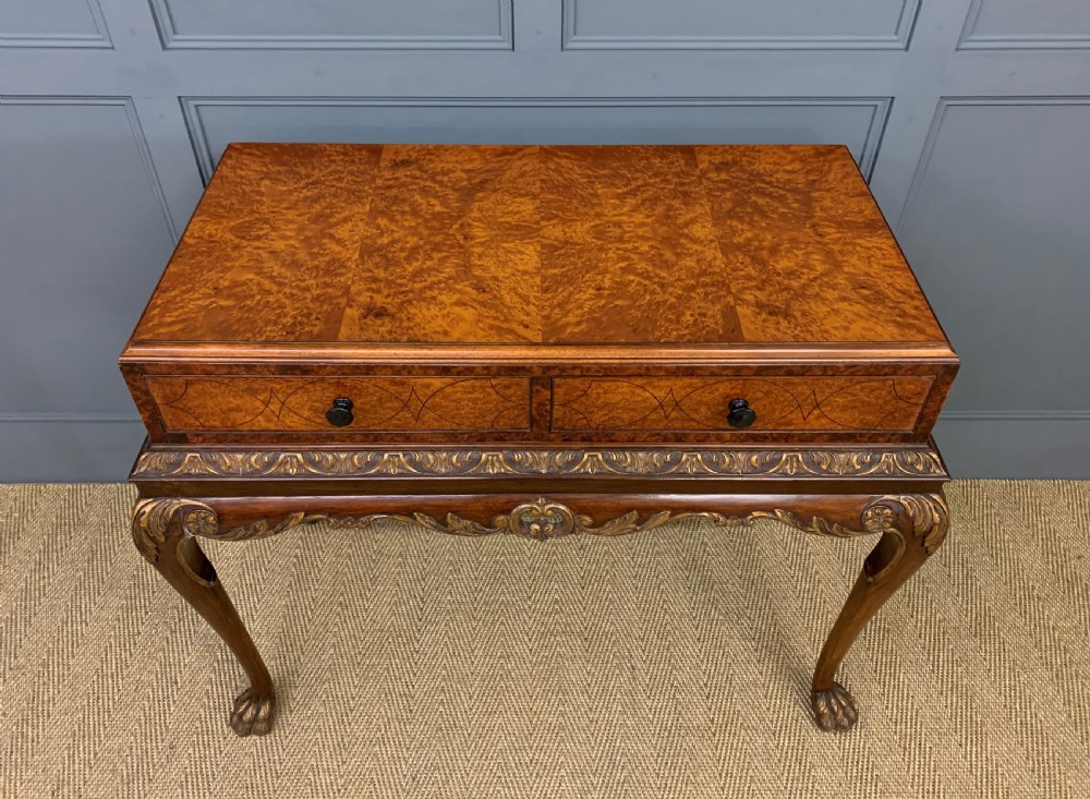 A burr walnut side table featuring two drawers with feather banding, carved egg-and-dart moulding, gilded accents, cabriole legs, and ball-and-claw feet. View II