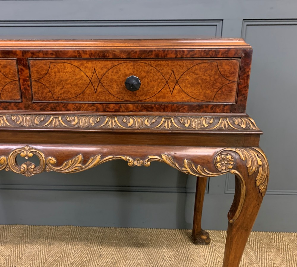 A burr walnut side table featuring two drawers with feather banding, carved egg-and-dart moulding, gilded accents, cabriole legs, and ball-and-claw feet. View IV