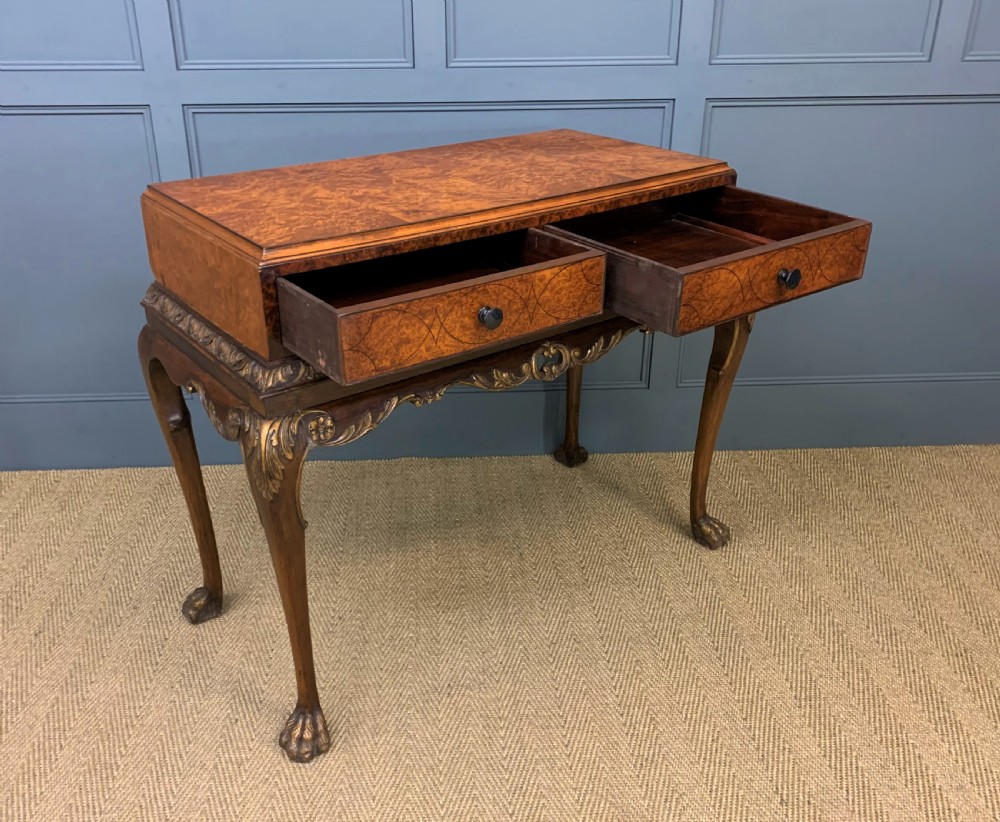 A burr walnut side table featuring two drawers with feather banding, carved egg-and-dart moulding, gilded accents, cabriole legs, and ball-and-claw feet. View IX