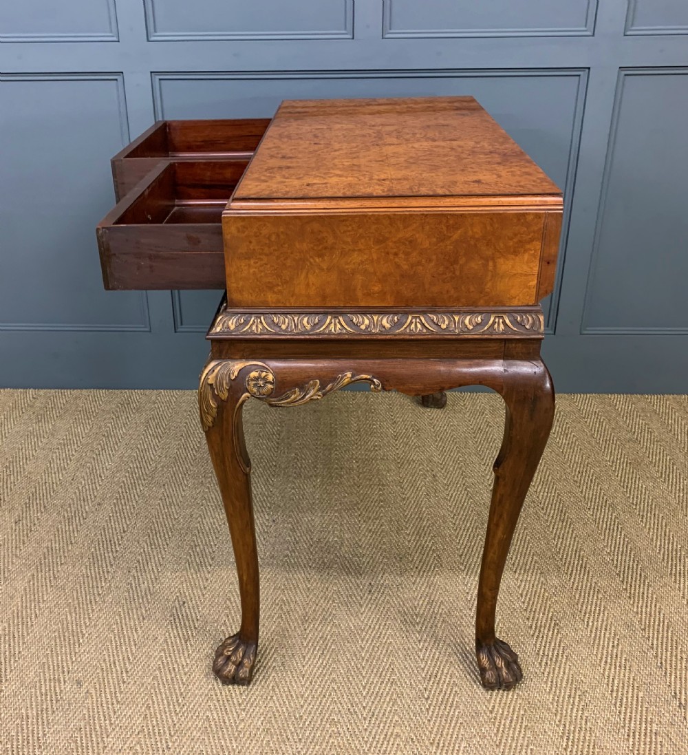 A burr walnut side table featuring two drawers with feather banding, carved egg-and-dart moulding, gilded accents, cabriole legs, and ball-and-claw feet. View XIV