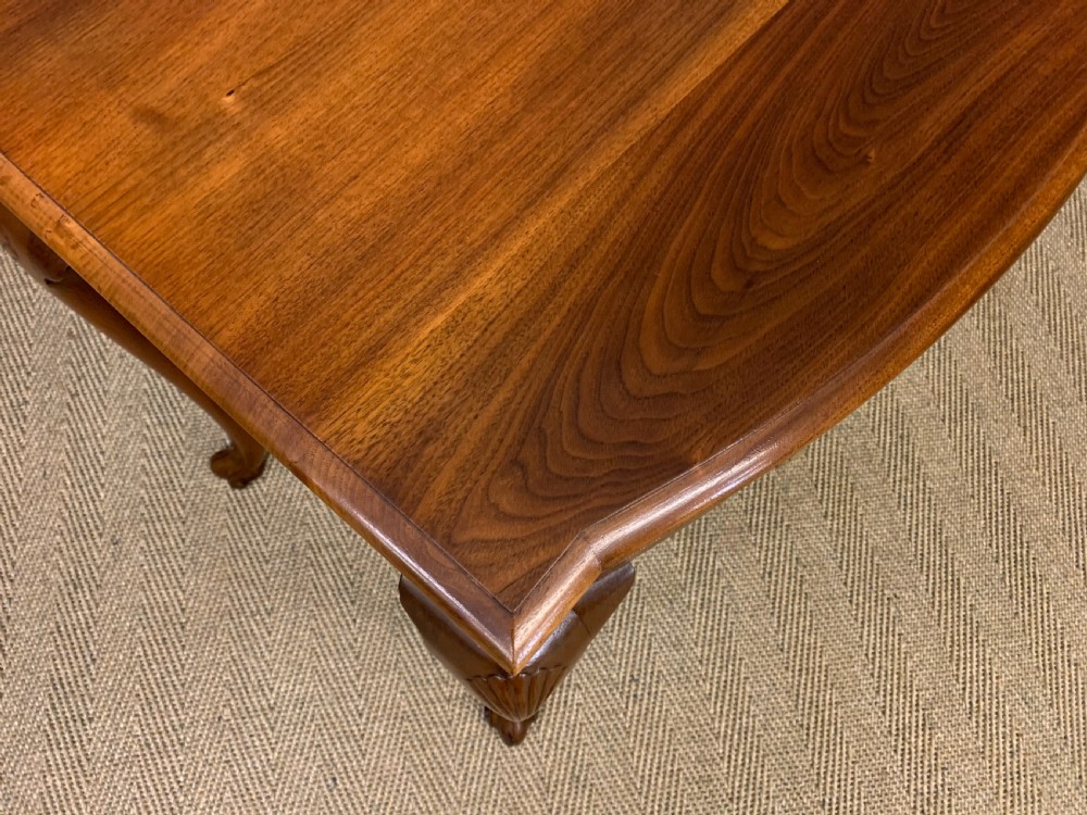 A warm brown burr walnut side table featuring a curved drawer front with brass handles and carved cabriole legs. View VIII