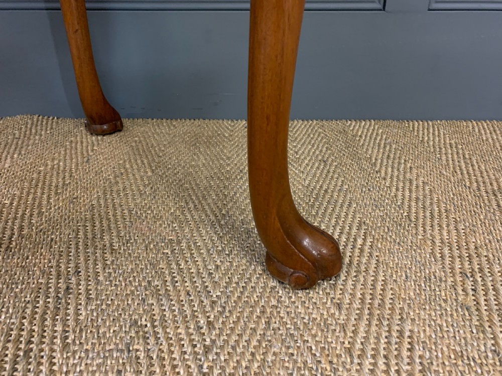 A warm brown burr walnut side table featuring a curved drawer front with brass handles and carved cabriole legs. View X