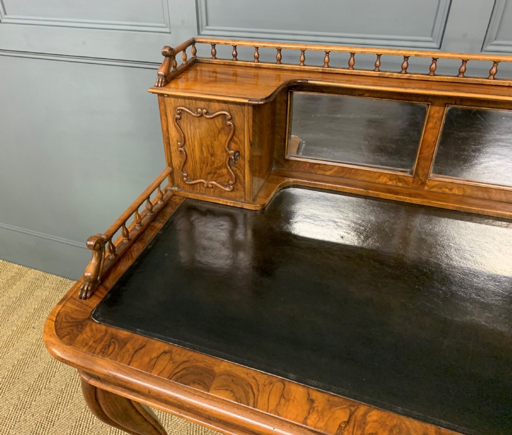 A 19th-century burr walnut bonheur du jour writing desk with a dark leather top, slender cabriole legs, and a gallery section featuring mirrors and small side cabinets. View IV