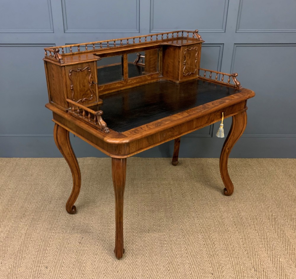A 19th-century burr walnut bonheur du jour writing desk with a dark leather top, slender cabriole legs, and a gallery section featuring mirrors and small side cabinets. View XII