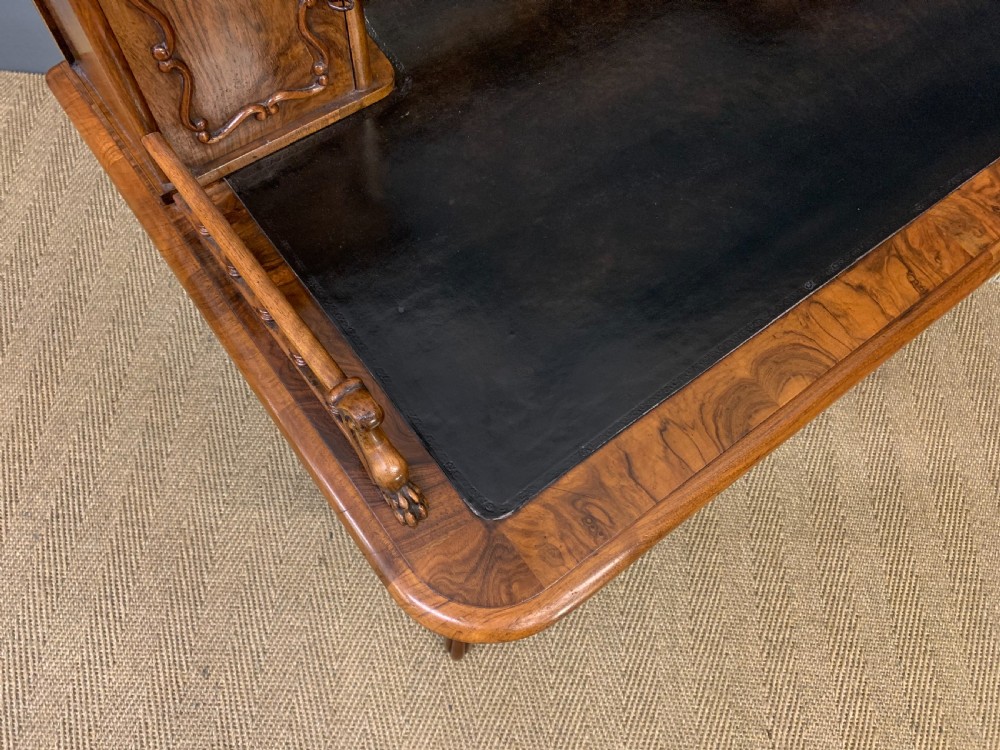 A 19th-century burr walnut bonheur du jour writing desk with a dark leather top, slender cabriole legs, and a gallery section featuring mirrors and small side cabinets. View XIV