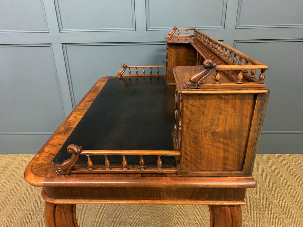 A 19th-century burr walnut bonheur du jour writing desk with a dark leather top, slender cabriole legs, and a gallery section featuring mirrors and small side cabinets. View XVIII